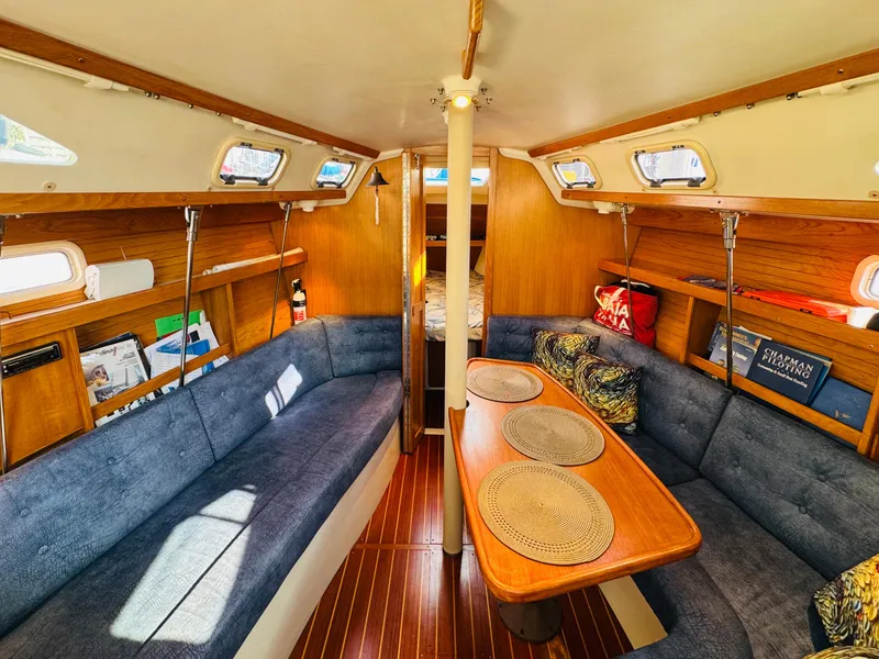 Slide: The Image of Interior of a 1998 Catalina 320 sailboat with cozy seating and wooden accents. - 21