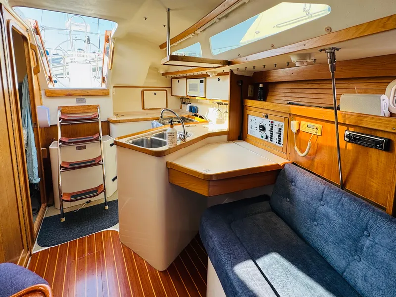 Slide: The Image of Interior of a 1998 Catalina 320 sailboat with wood finishes and cozy seating. - 22