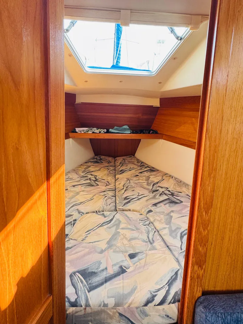 Slide: The Image of Interior cabin of 1998 Catalina 320 sailboat with cozy bedding and wooden finish. - 26