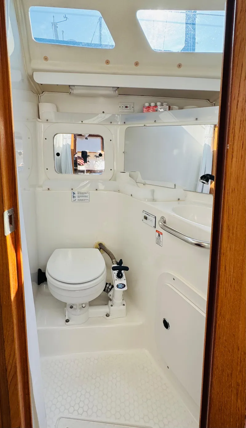 Slide: The Image of 1998 Catalina 320 yacht bathroom with white fixtures and natural light. - 27