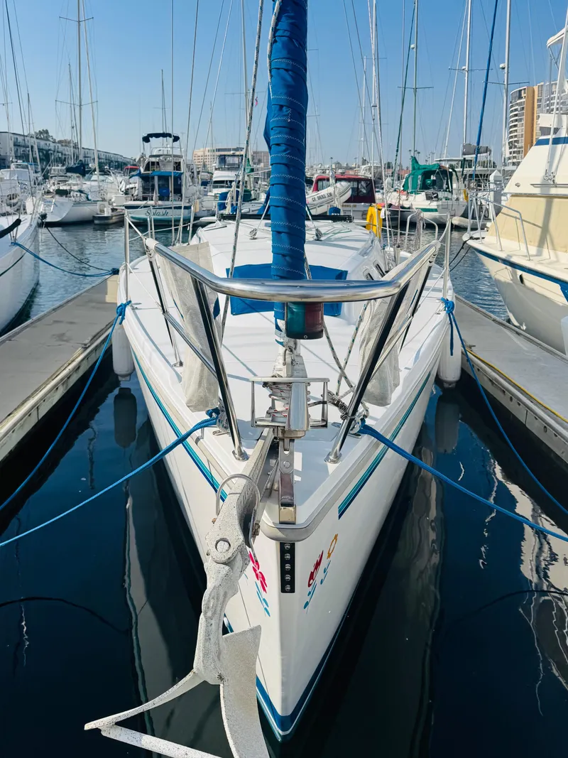 Slide: The Image of 1998 Catalina 320 sailboat docked in a marina, surrounded by other boats. - 3