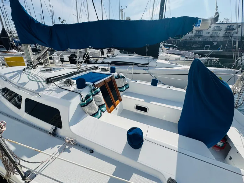 Slide: The Image of 1998 Catalina 320 sailboat docked, featuring a clean deck and blue sail cover. - 6