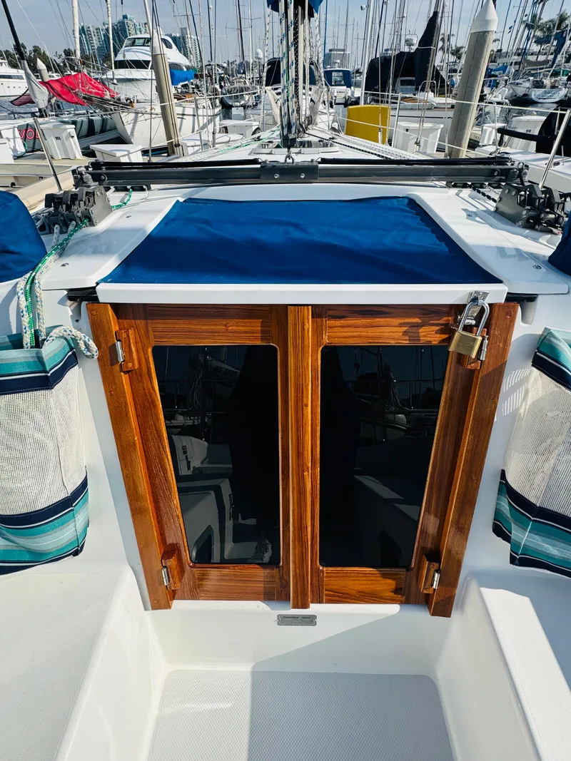Slide: The Image of 1998 Catalina 320 sailboat cockpit with wooden doors and blue cover. - 8