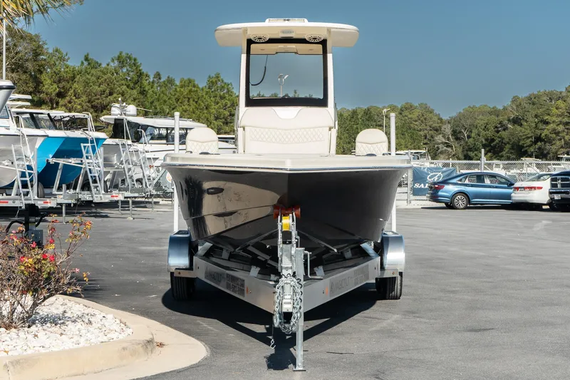 Slide: The Image of 2025 Scout 261 XSS boat on trailer in parking lot, surrounded by trees and other boats. - 3