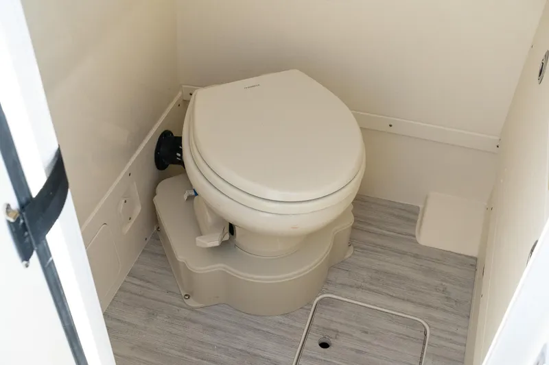 Slide: The Image of 2025 Scout 261 XSS boat bathroom with modern toilet and light wood flooring. - 33
