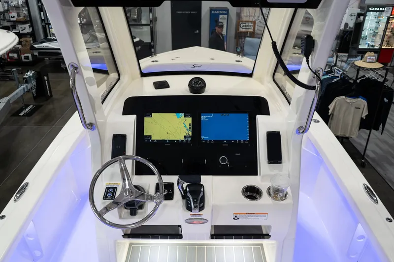 Slide: The Image of 2025 Scout 261 XSS boat dashboard with dual navigation screens and steering wheel. - 48