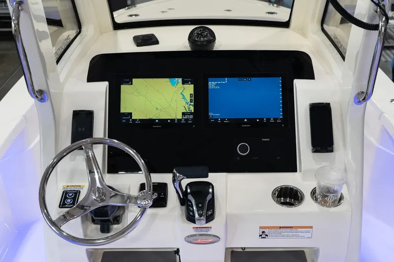 Slide: The Image of 2025 Scout 261 XSS boat dashboard with dual navigation screens and steering wheel. - 49
