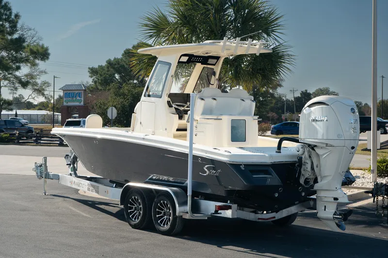 Slide: The Image of 2025 Scout 261 XSS boat on trailer, parked outdoors, with palm trees in the background. - 5