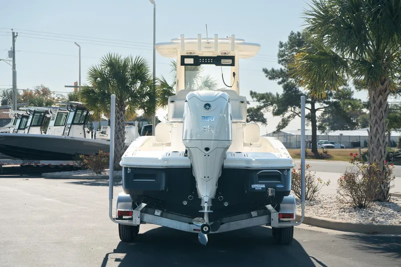 Slide: The Image of 2025 Scout 261 XSS boat on trailer, parked outdoors near palm trees. - 6