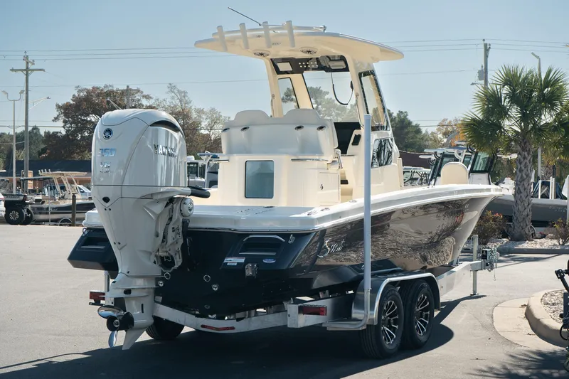 Slide: The Image of 2025 Scout 261 XSS boat on trailer, parked outdoors, featuring sleek design and powerful engine. - 7