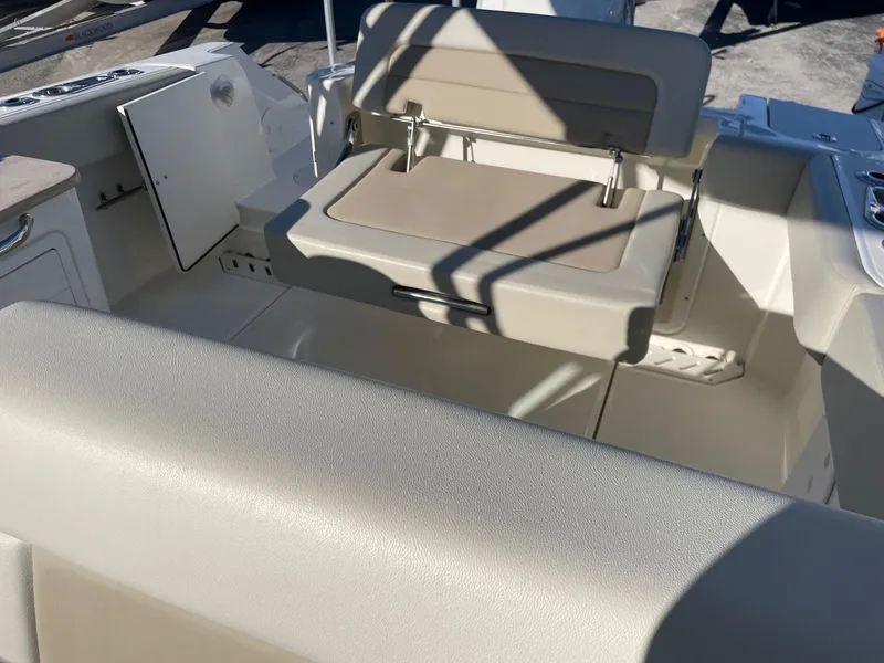 Slide: The Image of 2021 Boston Whaler 240 Vantage boat interior with beige seating and storage compartments. - 5