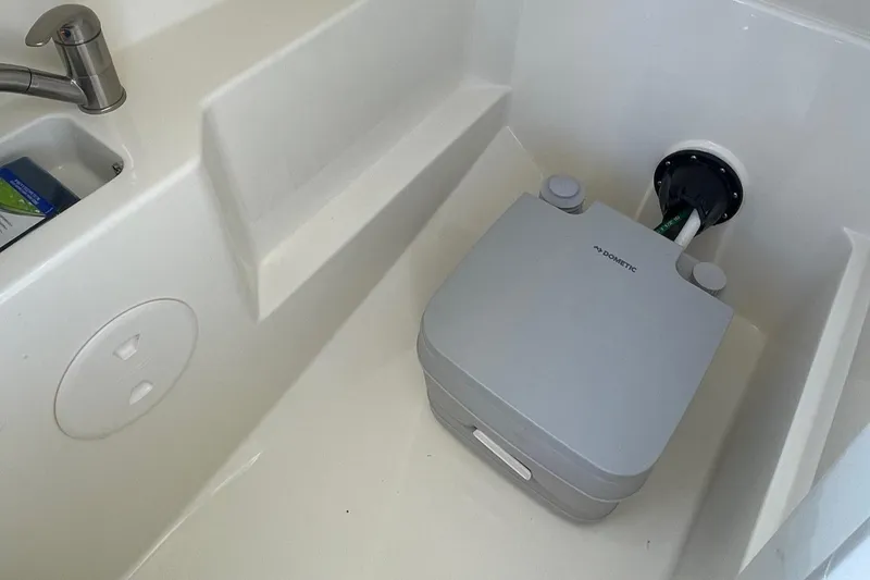 Slide: The Image of Boston Whaler 240 Vantage 2021 boat interior with portable toilet and sink. - 8