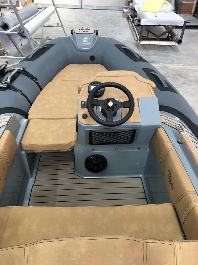 Slide: The Image of 2025 Ranieri Cayman One Luxury Tender with tan seating and sleek steering console. - 9