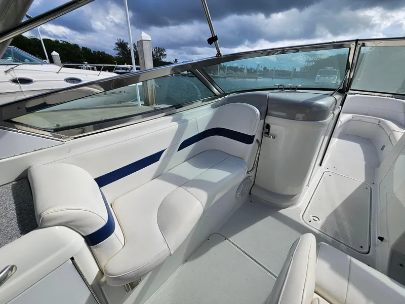 Slide: The Image of 2007 Formula 280 Bowrider interior with white seating and blue accents, under cloudy sky. - 4