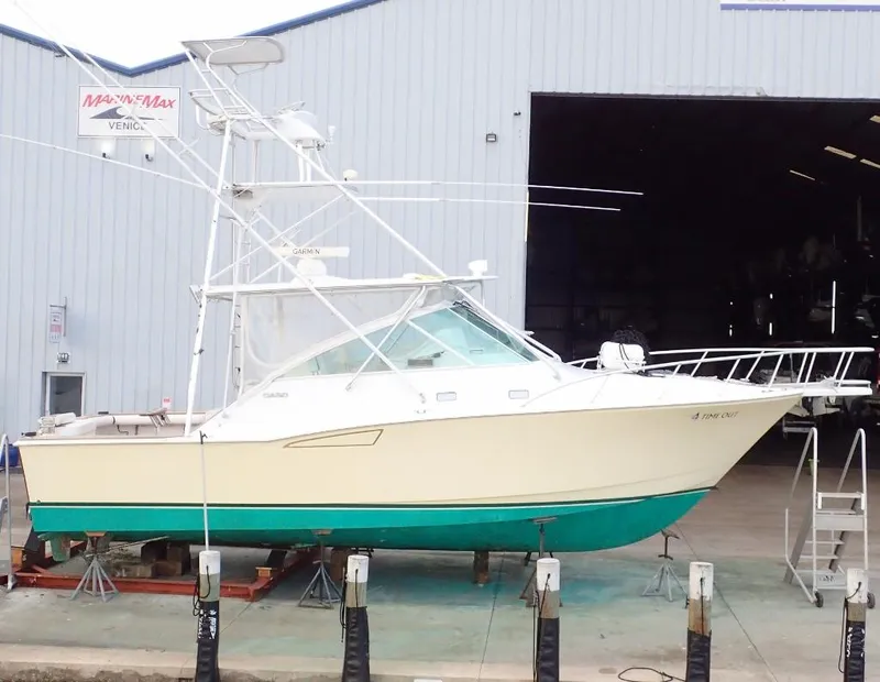 The Image of 2000 Cabo 35 Express boat on dry dock outside a large warehouse. - 0