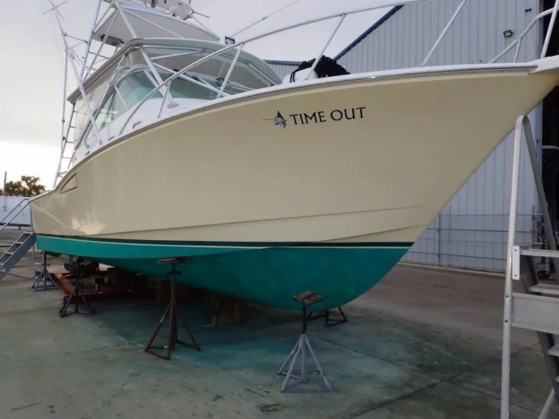 Slide: The Image of 2000 Cabo 35 Express boat named "Time Out" on dry dock. - 11