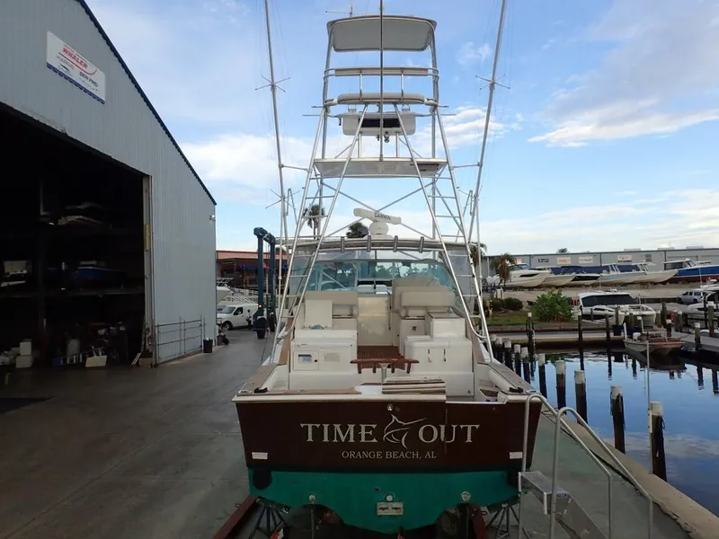 Slide: The Image of 2000 Cabo 35 Express boat docked, rear view, with "Time Out" name visible. - 17