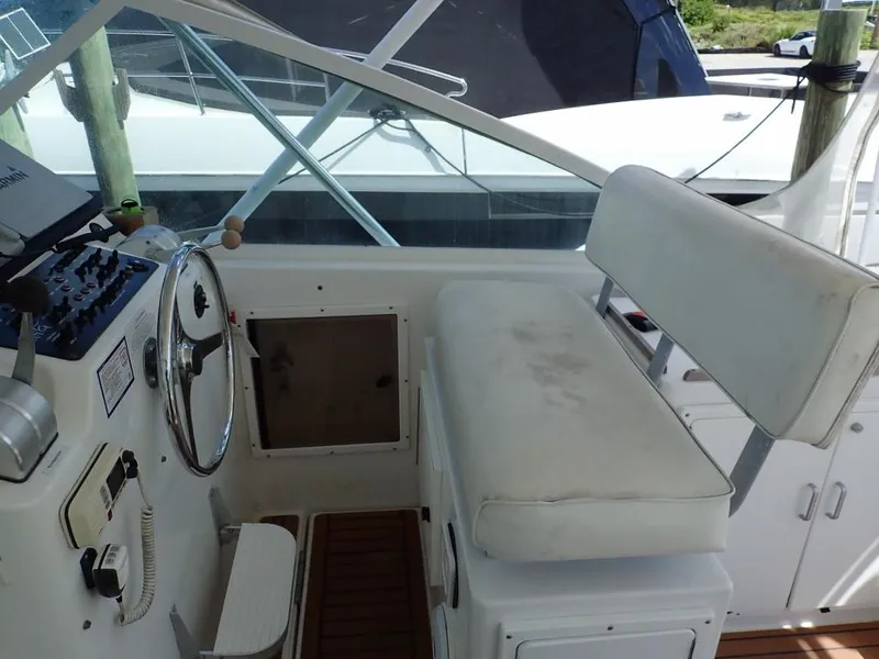 Slide: The Image of Helm of 2000 Cabo 35 Express boat with steering wheel and seating. - 19
