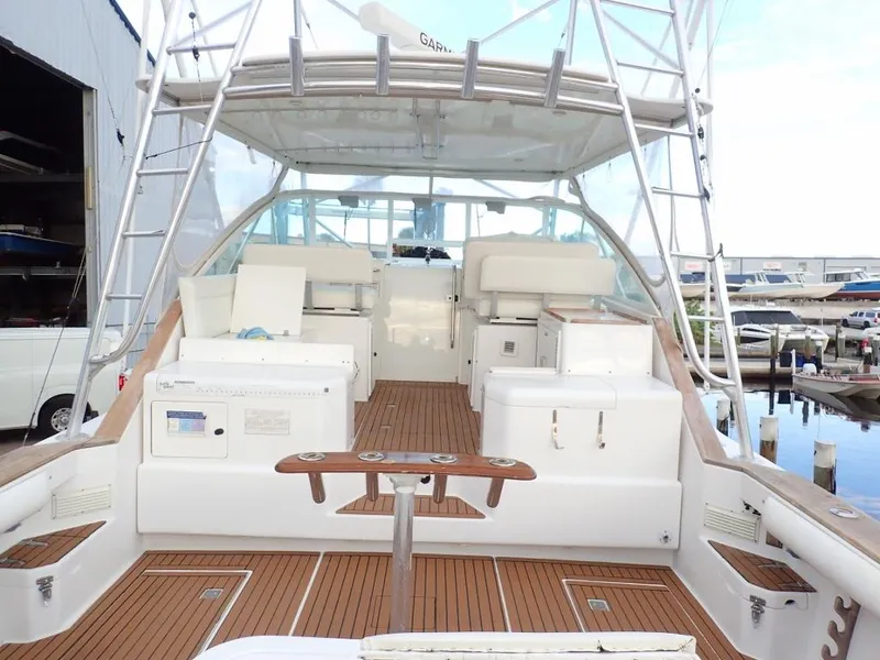 Slide: The Image of 2000 Cabo 35 Express yacht with spacious deck and seating at marina. - 2