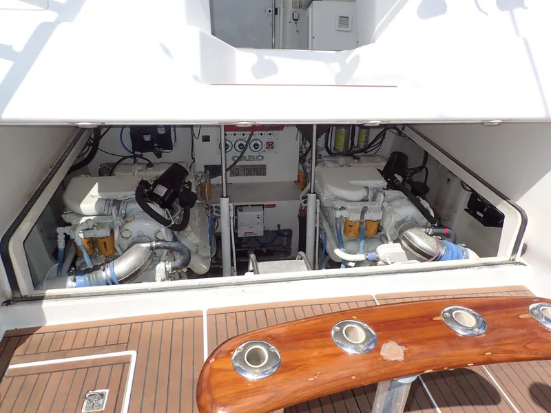 Slide: The Image of Engine compartment of 2000 Cabo 35 Express yacht, showcasing dual engines and teak deck. - 21