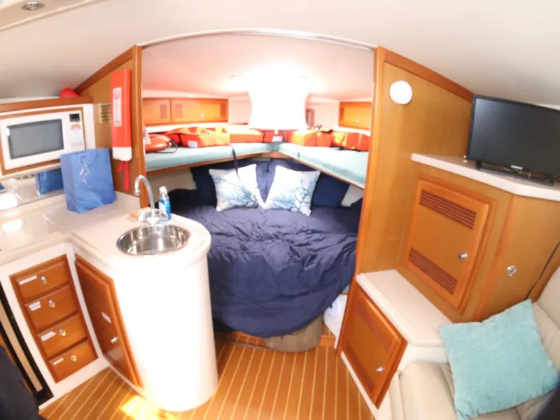 Slide: The Image of Interior of 2000 Cabo 35 Express boat with cozy cabin and kitchenette. - 4