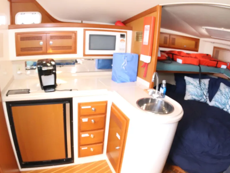 Slide: The Image of Interior of 2000 Cabo 35 Express yacht with kitchenette and cozy sleeping area. - 5