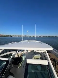 Slide: The Image of 2021 Pursuit DC 266 Dual Console boat on calm water under clear blue sky. - 14