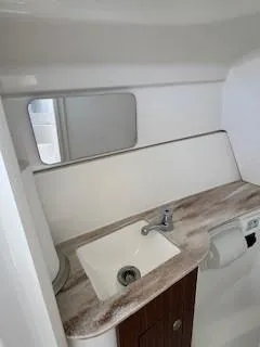 Slide: The Image of 2021 Pursuit DC 266 Dual Console boat bathroom with sink and mirror. - 15