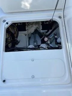 Slide: The Image of 2021 Pursuit DC 266 Dual Console boat storage compartment with visible wiring and equipment. - 38