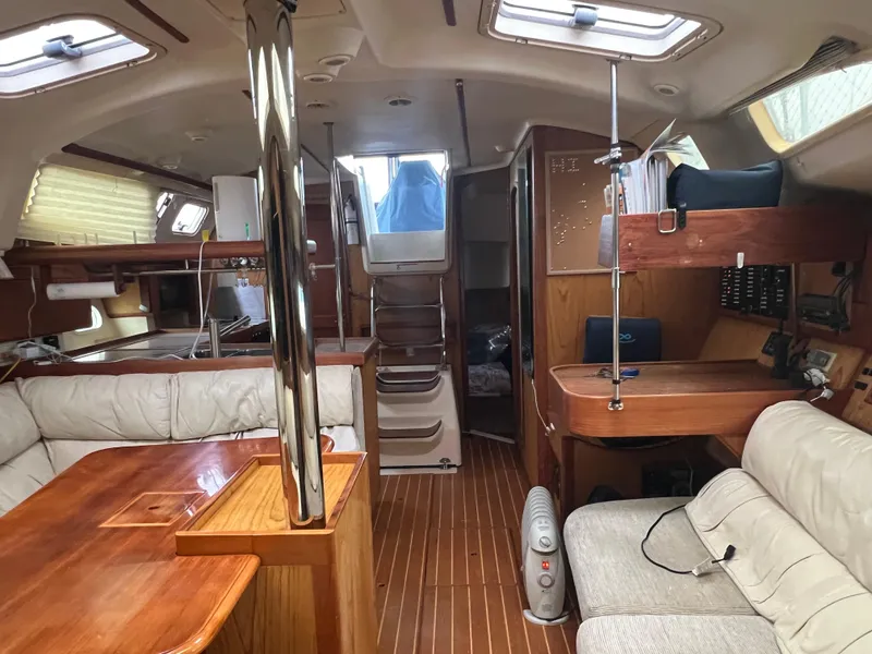 Slide: The Image of Interior of a 2000 Hunter 410 sailboat with wood finishes and seating area. - 14