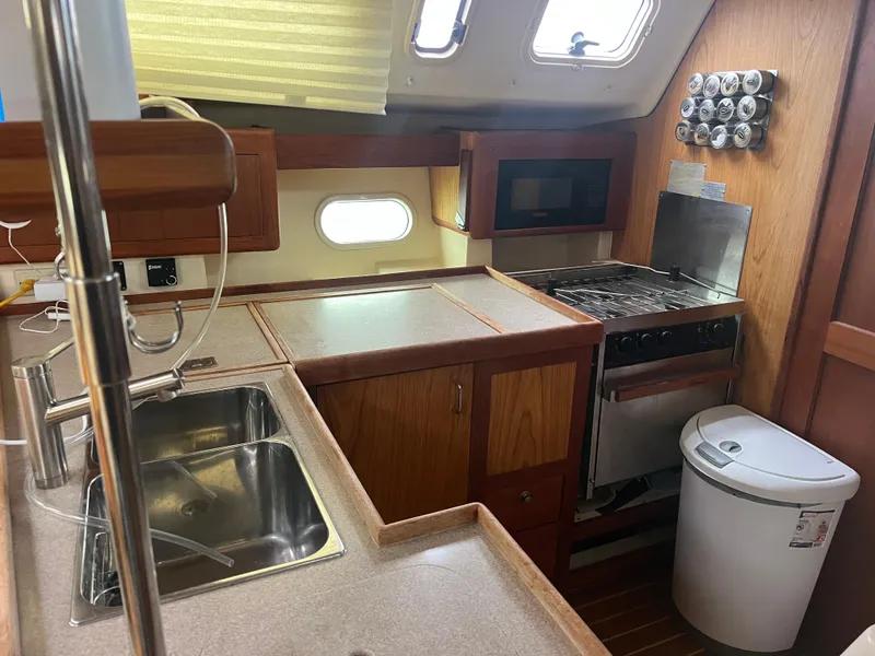 Slide: The Image of Kitchen area in a 2000 Hunter 410 sailboat with sink, stove, and storage. - 19
