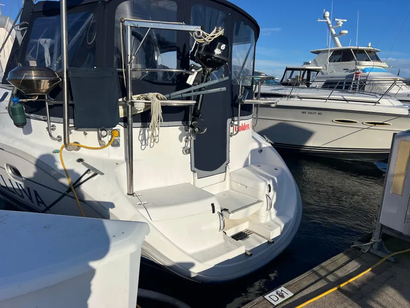 Slide: The Image of 2000 Hunter 410 sailboat named "Helluva" docked at marina under clear blue sky. - 2