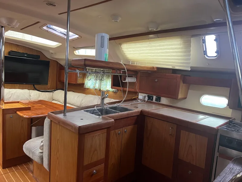 Slide: The Image of Interior of 2000 Hunter 410 sailboat with wood cabinetry and seating area. - 20