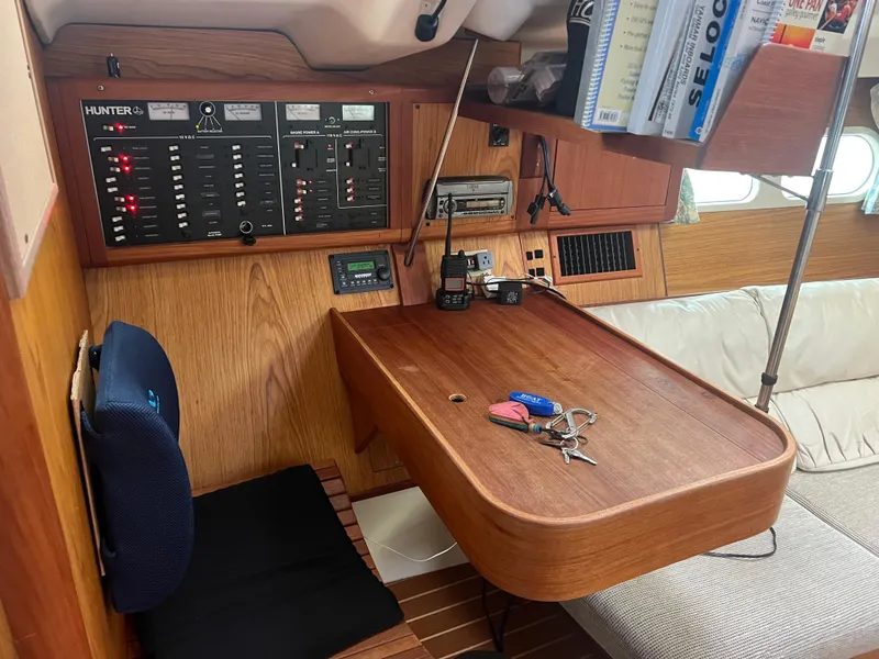 Slide: The Image of Navigation station in a 2000 Hunter 410 sailboat with control panel and seating area. - 21