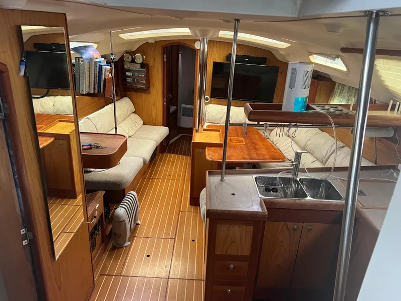 Slide: The Image of Interior of 2000 Hunter 410 sailboat with wood finish and cozy seating area. - 22