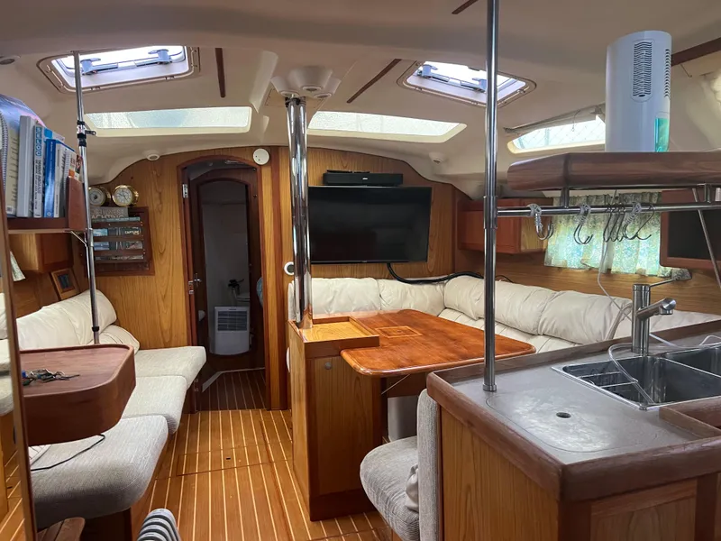 Slide: The Image of Interior of a 2000 Hunter 410 sailboat with wood finish and cozy seating area. - 23
