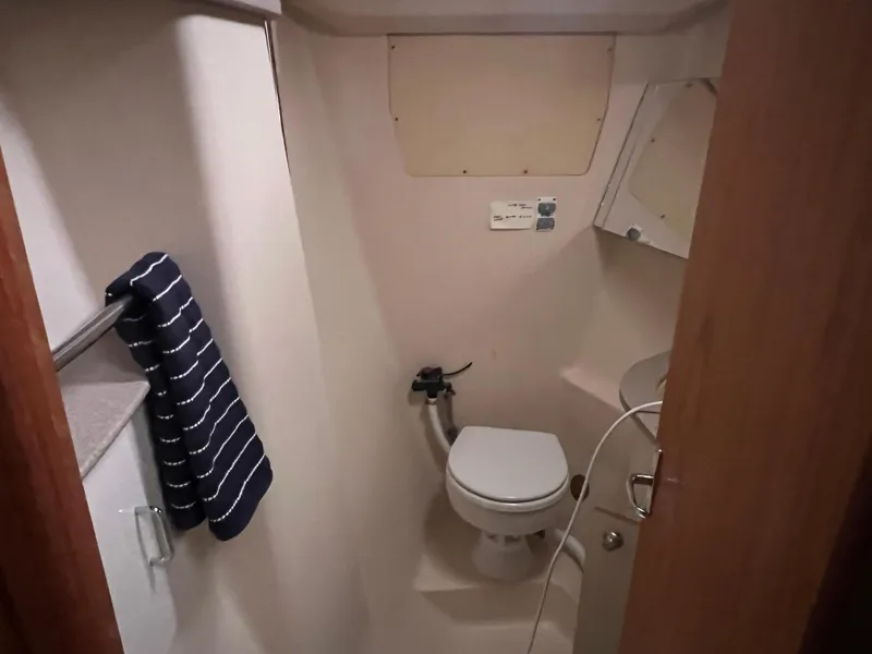 Slide: The Image of Compact bathroom in 2000 Hunter 410 boat with toilet and striped towel. - 26