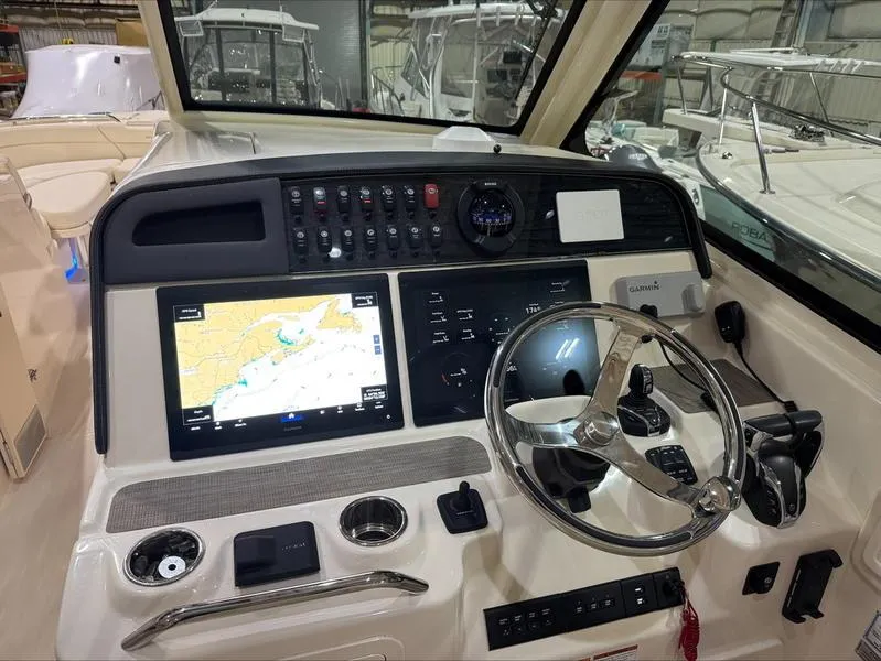 Slide: The Image of 2024 Grady-White 375 Freedom boat dashboard with navigation screens and steering wheel. - 10