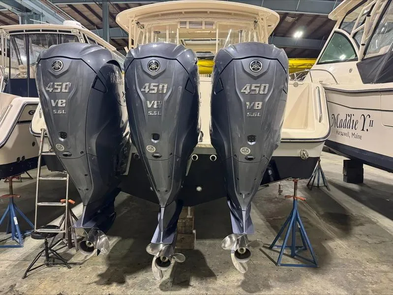 Slide: The Image of 2024 Grady-White 375 Freedom boat with triple Yamaha 450 V8 engines in a showroom. - 11