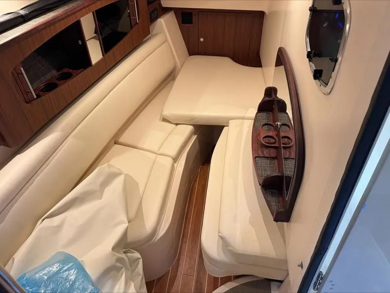 Slide: The Image of 2024 Grady-White 375 Freedom cabin interior with cream seating and wood accents. - 14