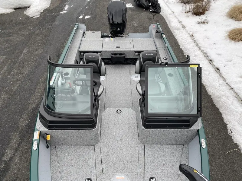 Slide: The Image of 2025 Lund 1775 Adventure Sport boat with dual windshields, parked on snowy pavement. - 13