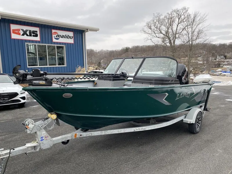 Slide: The Image of 2025 Lund 1775 Adventure Sport boat on trailer, parked outside dealership. - 2
