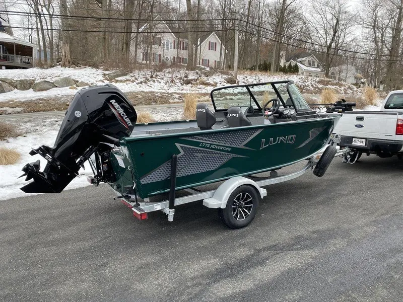 Slide: The Image of 2025 Lund 1775 Adventure Sport boat on trailer, parked on snowy roadside. - 4