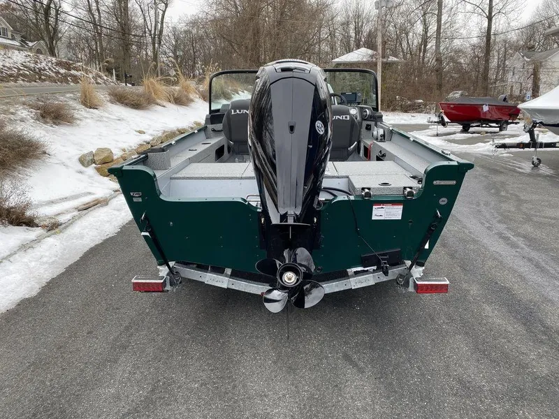 Slide: The Image of 2025 Lund 1775 Adventure Sport boat with outboard motor, parked on snowy driveway. - 5
