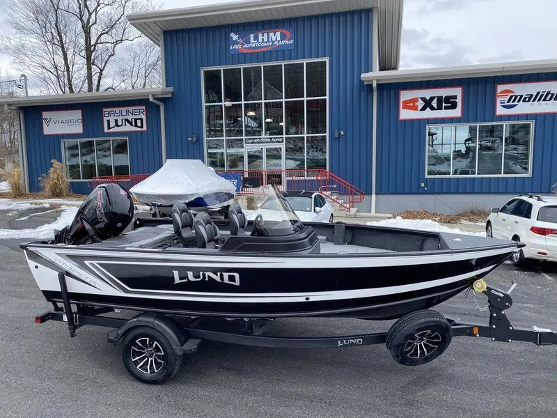 The Image of 2025 Lund 1775 Impact XS SS boat on trailer outside dealership. - 0