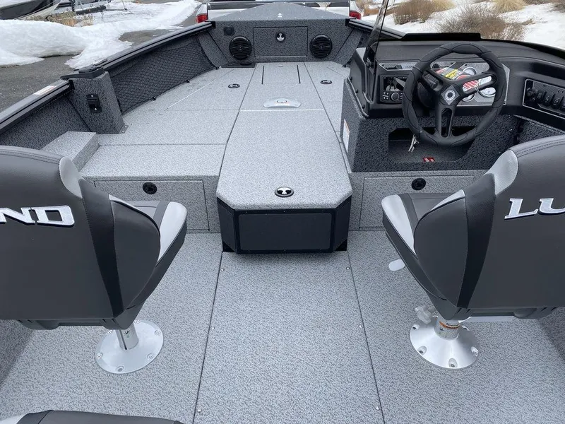 Slide: The Image of 2025 Lund 1775 Impact XS SS boat interior with gray seating and steering console. - 15