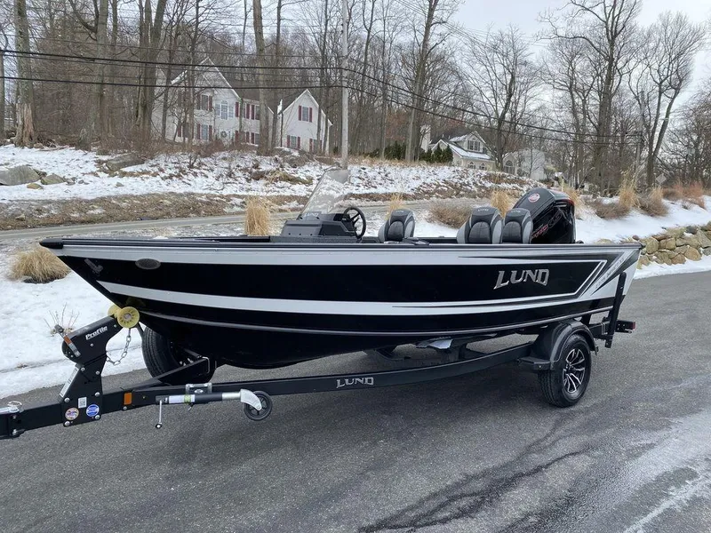 Slide: The Image of 2025 Lund 1775 Impact XS SS boat on trailer, parked on snowy road. - 4