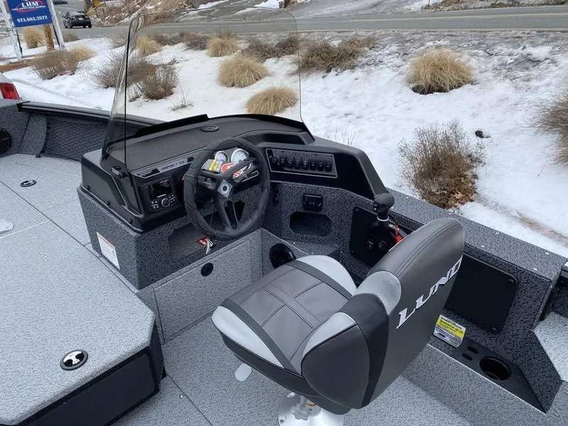 Slide: The Image of 2025 Lund 1775 Impact XS SS boat interior with steering console and seat. - 9