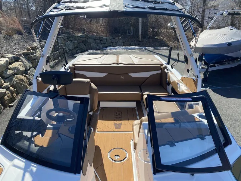 Slide: The Image of 2025 Axis A20 boat interior with open windshield, tan seating, and wood flooring. - 10