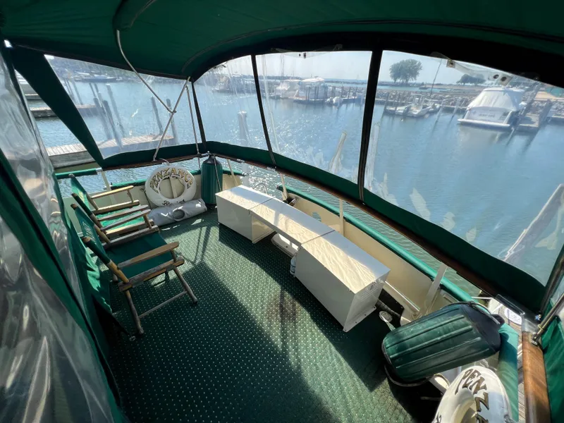 Slide: The Image of 1967 Hatteras 41 Twin Cabin yacht interior with marina view, featuring green seating and carpet. - 10